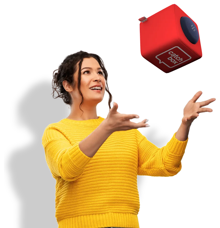 Mulher de camisola amarela prestes a apanhar um cubo Catchbox vermelho lançado no ar.