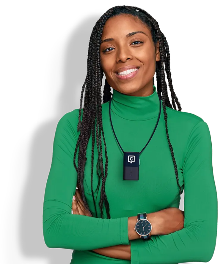 Mulher de camisola verde, de braços cruzados, com o pequeno microfone Catchbox Plus Clip ao pescoço.